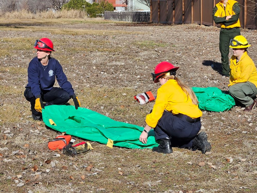 Students at the 2025 Eastern Kansas Wildfire Academy learn to deploy shelters.