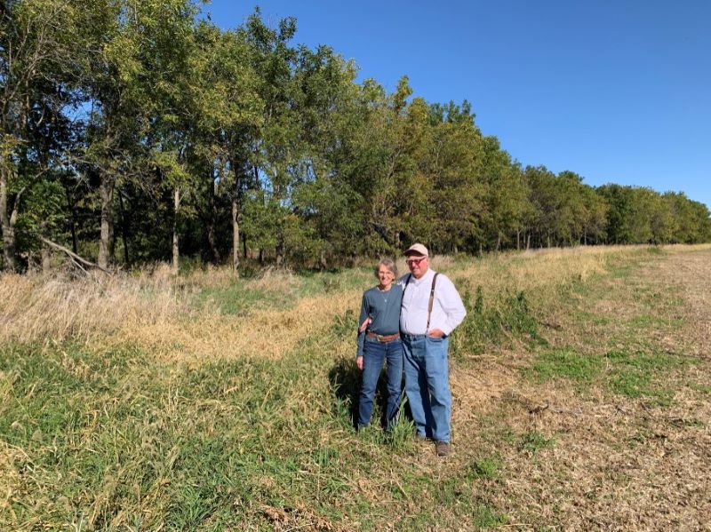 Jim and Janet in front of windbreak